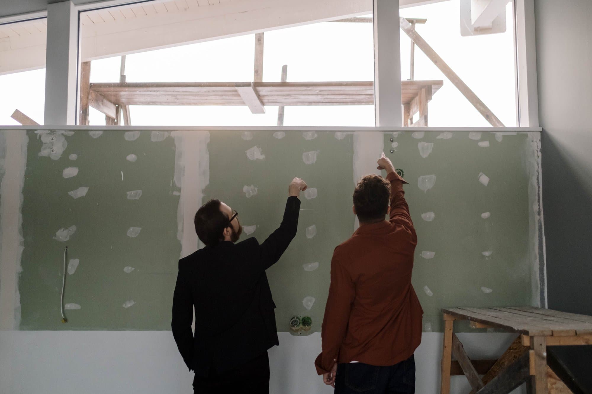 Professionnels échangeant devant un mur lors d'une visite technique